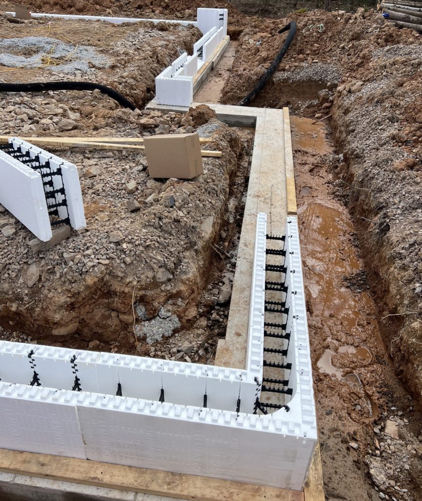 Element ICF being placed on the footings in the first row.