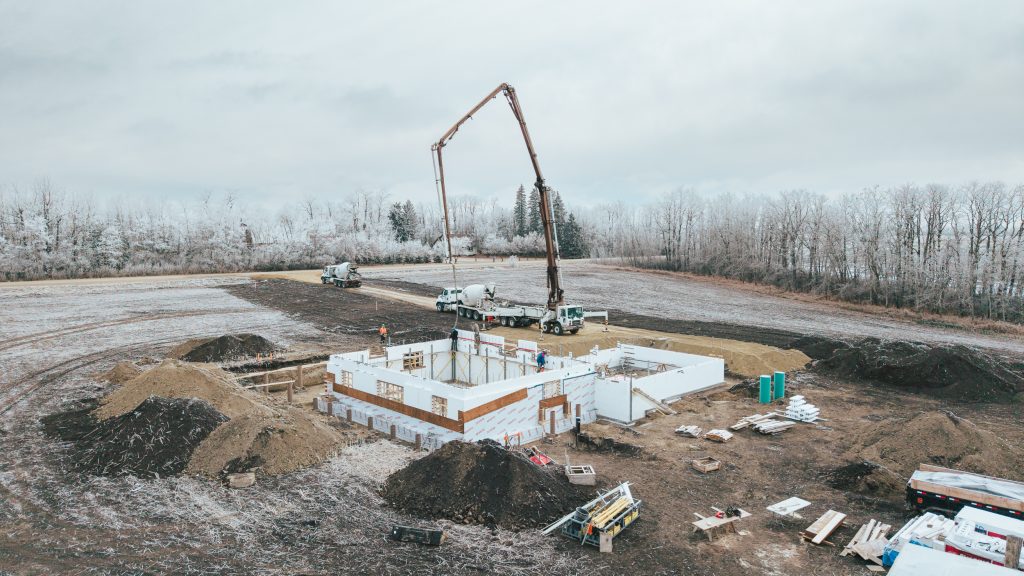 As the crew places the next lift of concrete, careful vibration and consolidation ensure a strong bond at the cold joint — protecting both structural continuity and the airtight performance required for Passive House construction.