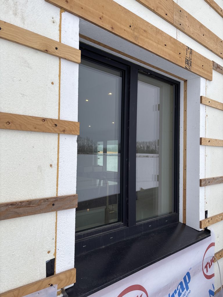 Window opening showing layered insulation around the ProBuck buck. Additional EPS insulation helps maintain continuous thermal protection and reduce heat loss at the window-to-wall transition.